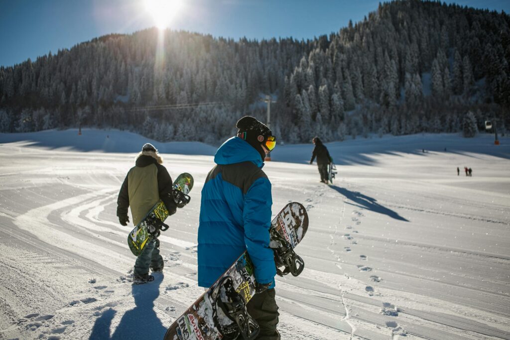 pexels-photo-848612-848612 Group of snowboarders walking up a snowy ski slope during a sunny winter day in the mountains.